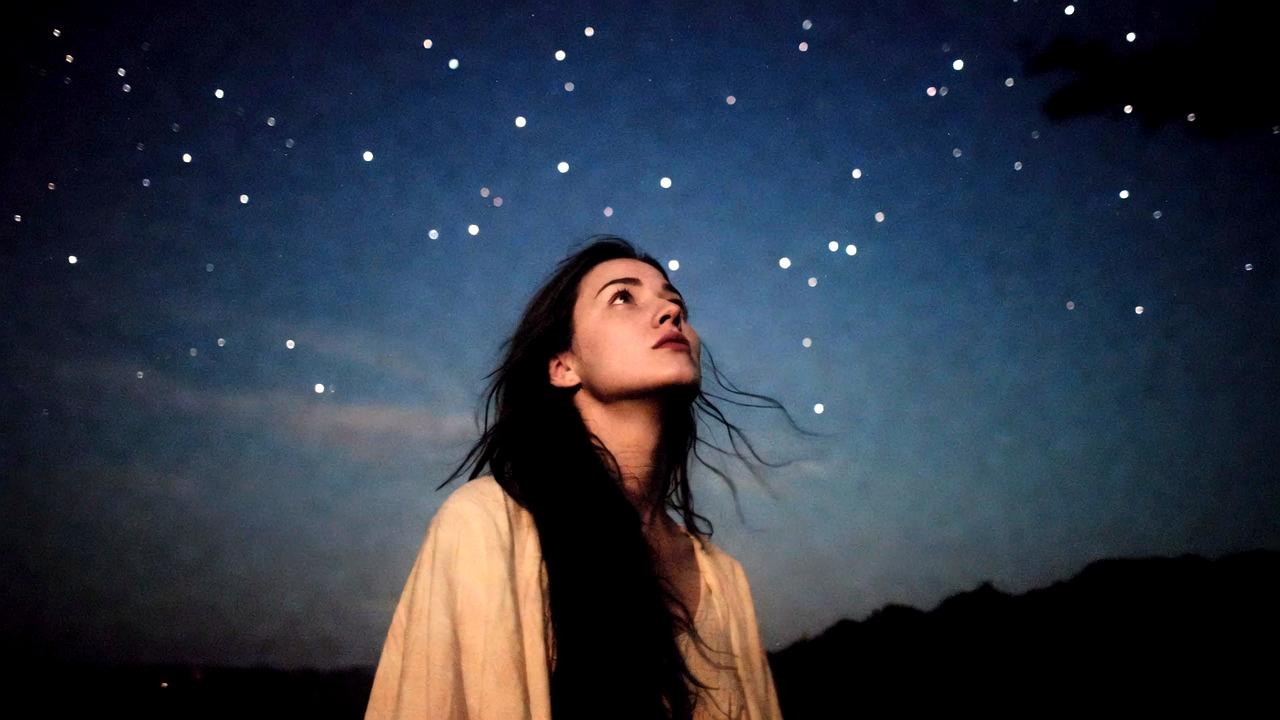 静かな時間の中でひとり考え込む人物と淡い光の広がり